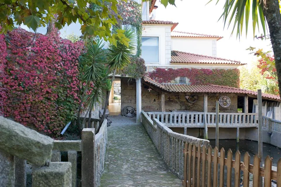 Edifício da Quinta entre vegetação e caminhos de pedra